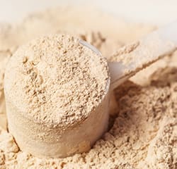 close up of a scoop of brown protein powder